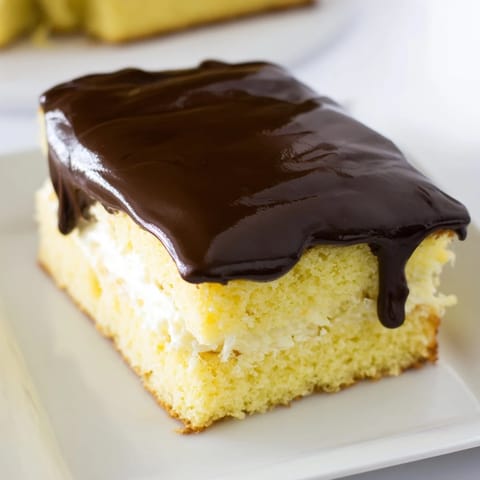 This homemade Ho Ho Cake boasts a moist yellow cake base, filled with vanilla cream and chocolate.