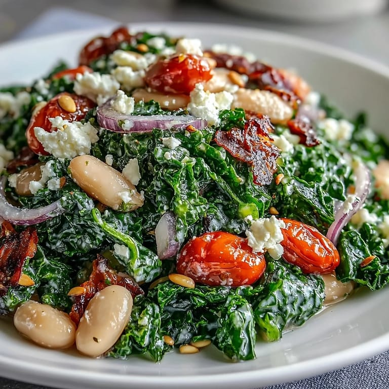 Serving suggestion for White Bean and Kale Salad with cherry tomatoes, red onion, and crumbled feta on a rustic table.